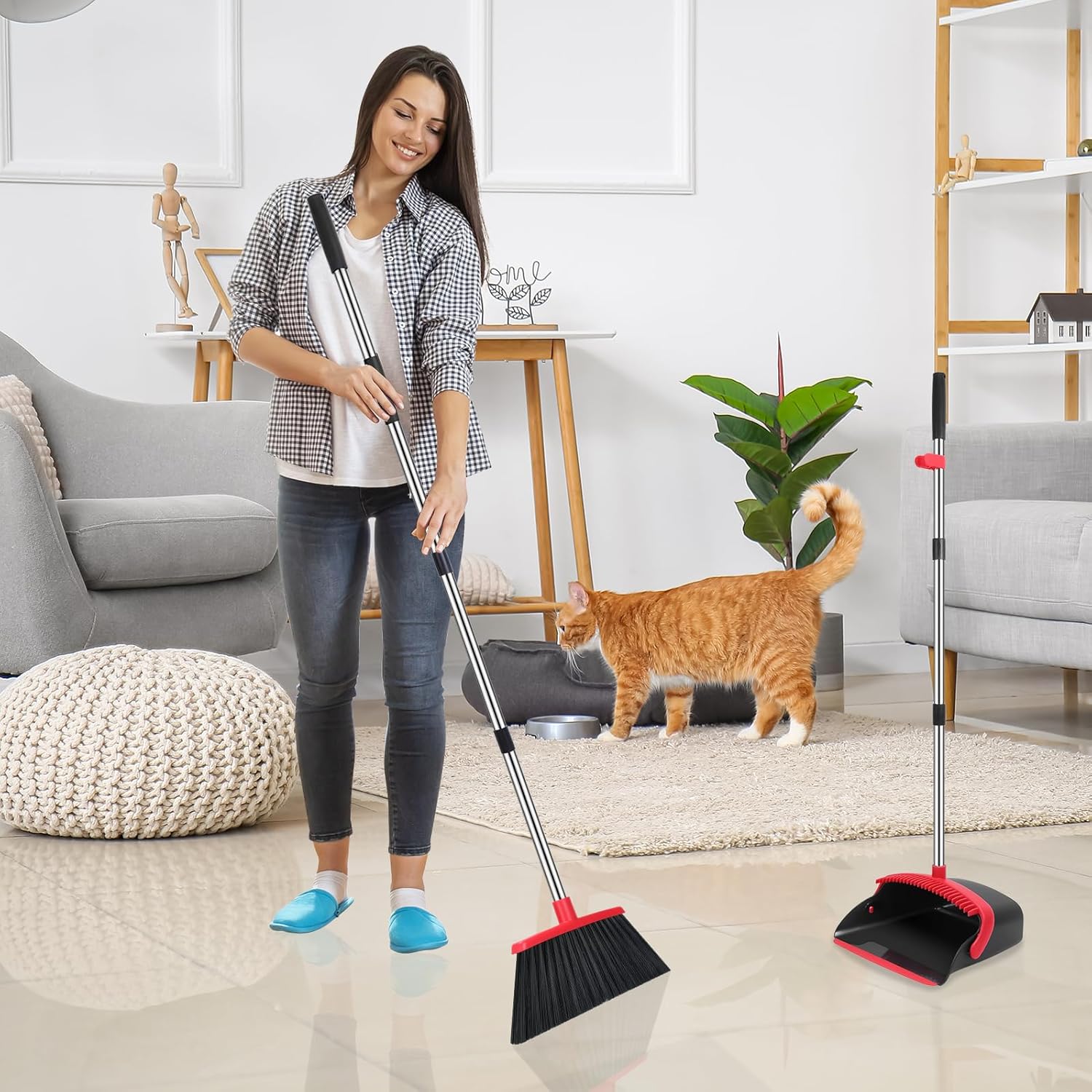 Woman cleaning a living room with a broom and dustpan, cat watching from the floor.